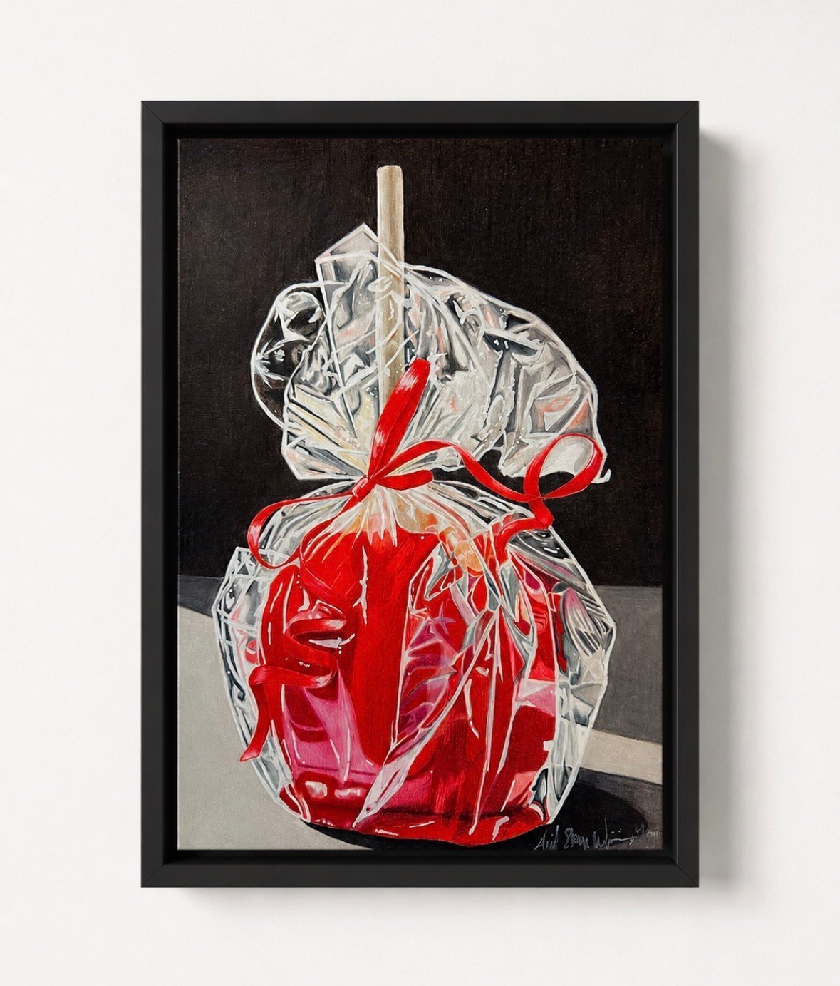 Red bell pepper wrapped in clear plastic with wooden stem, framed artwork on dark background