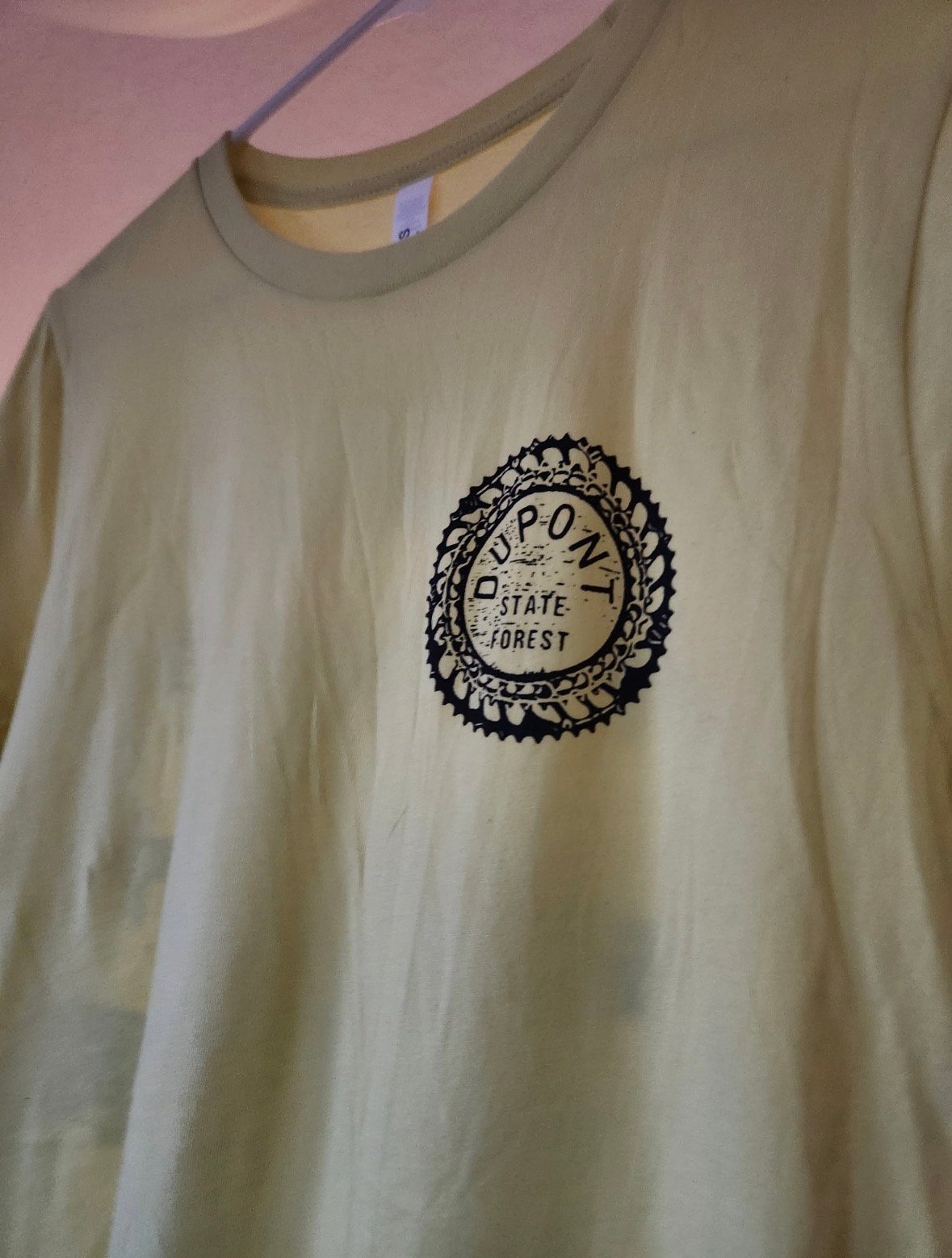 Cream-colored t-shirt with a black circular seal logo reading Depot State Forest on the chest